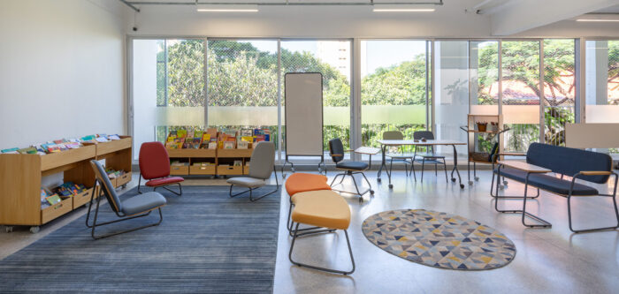 sala de leitura em escola inovadora, com poltronas, estantes biblioteca e lousa