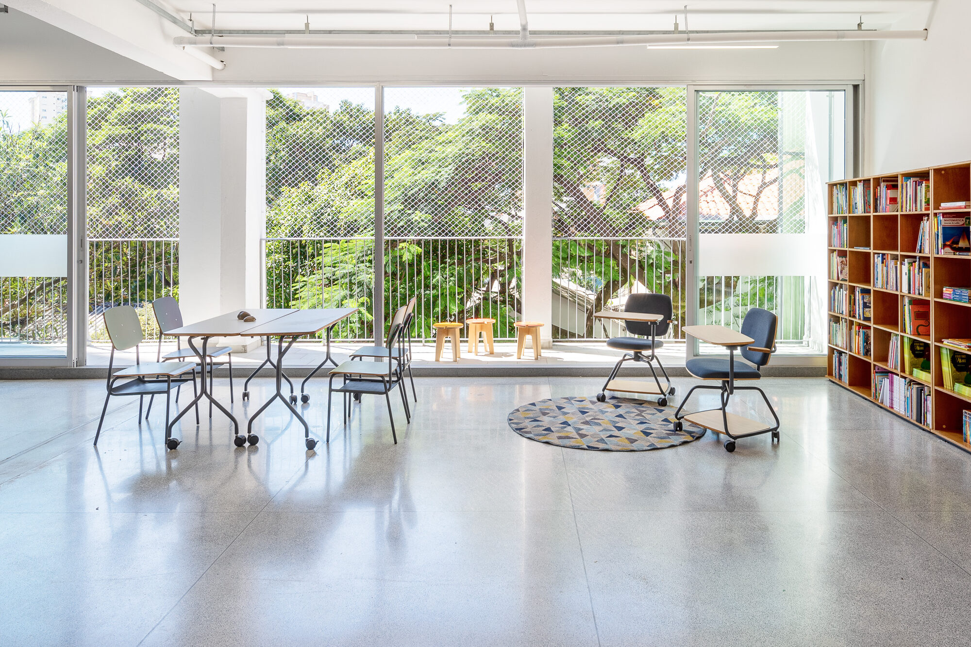 sala de aula iluminada com carteiras universitárias em escola inovadora