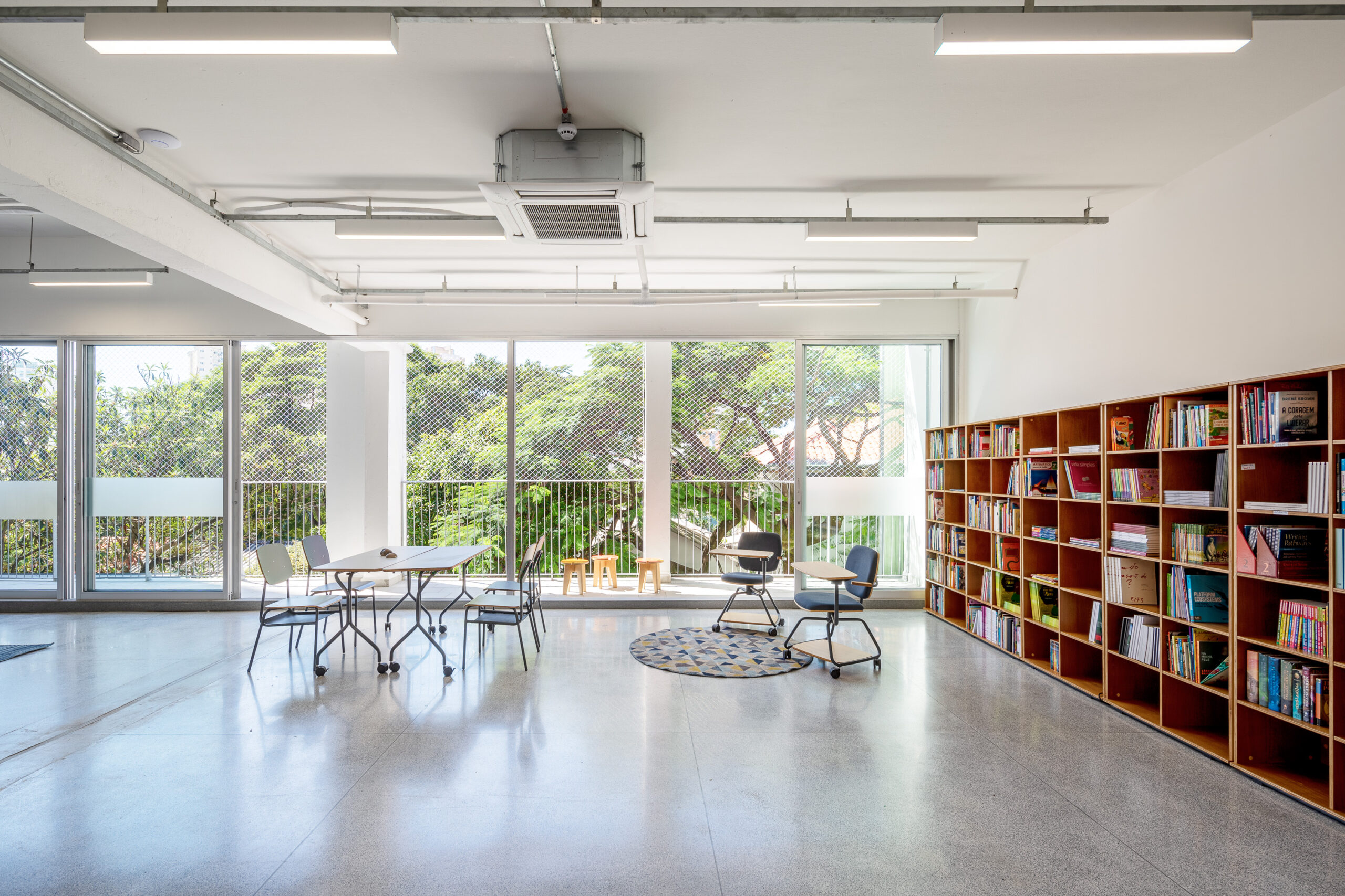 ambiente de estudo com cadeira e mesa rebatível, cadeira com prancheta e escaninho