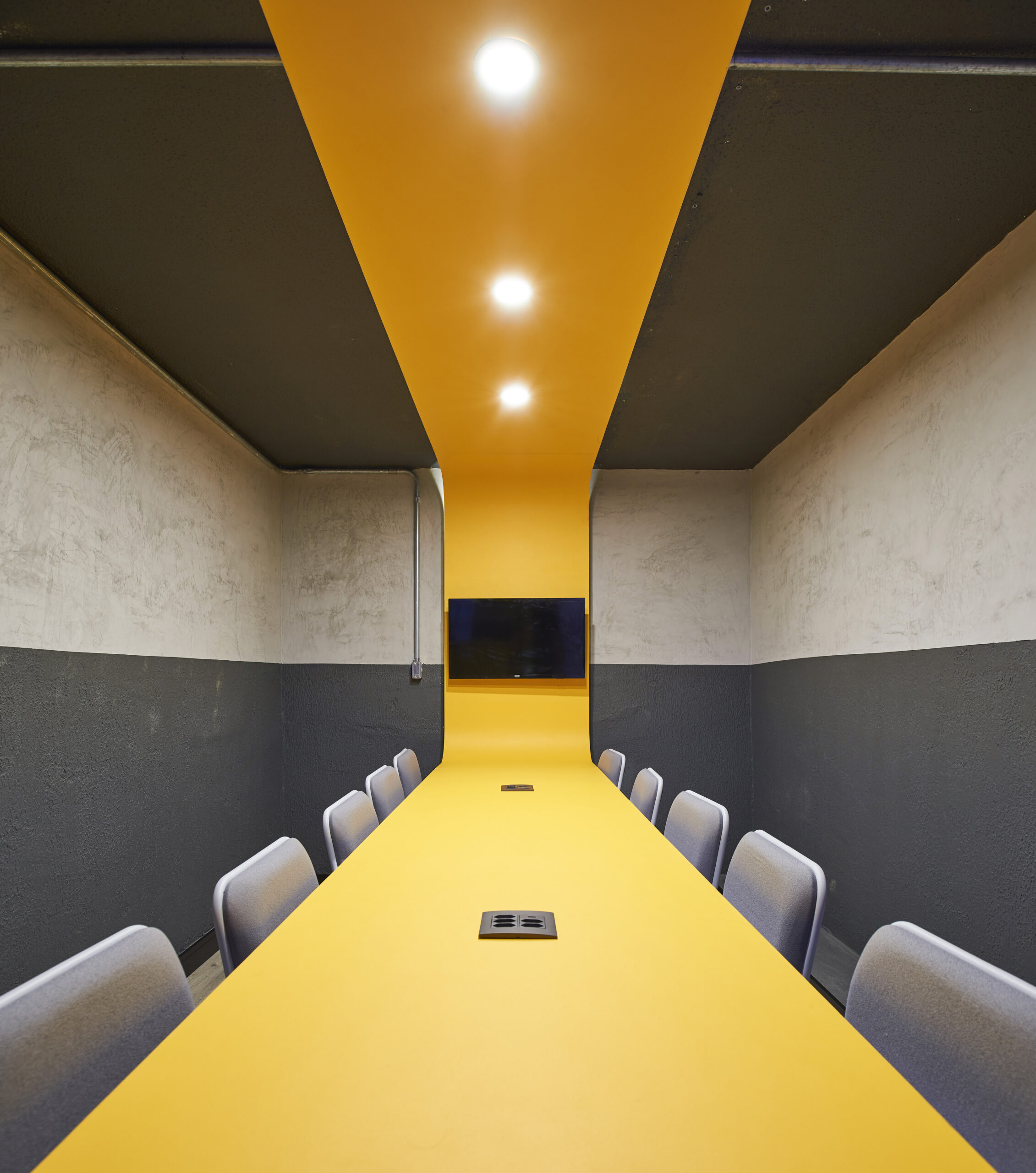 efeito ótico do tampo da mesa de sala de reunião que se conecta até o teto através de uma extensão de madeira