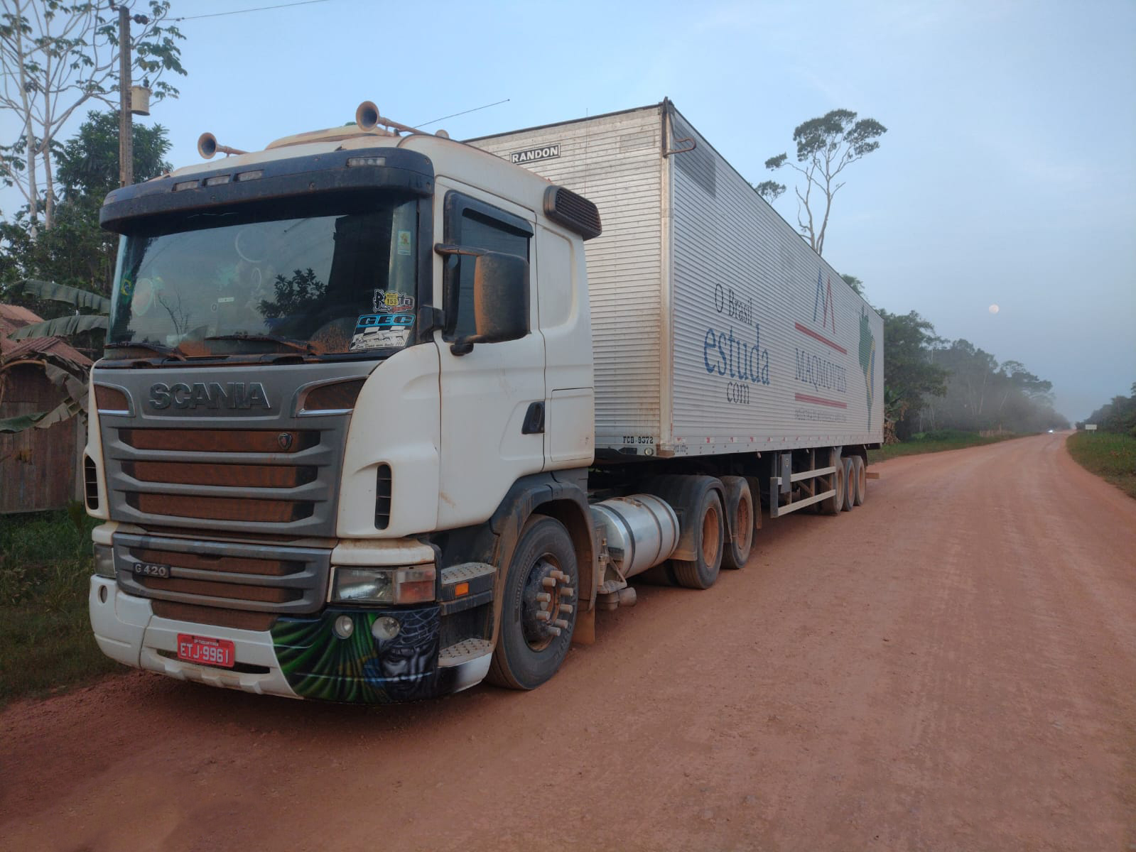 foto de um caminhão de transporte em estrada de terra