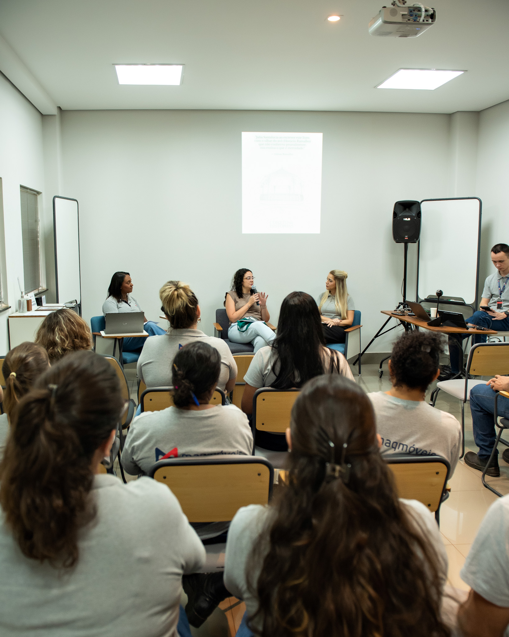 Coreto de histórias: pessoas ouvindo alguém falar em uma sala.