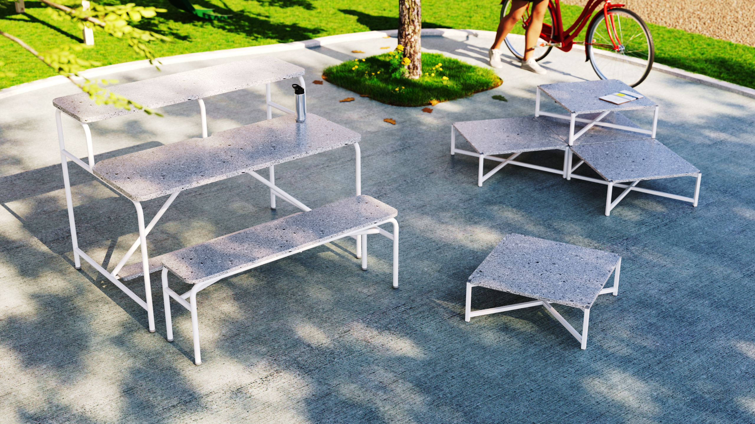 Mobiliário externo modular em um pátio, incluindo bancos e mesas de diferentes alturas, com uma bicicleta e árvores ao fundo.